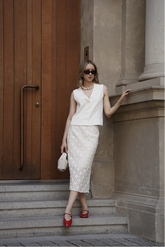 a lady in a white vest and a white openwork dress